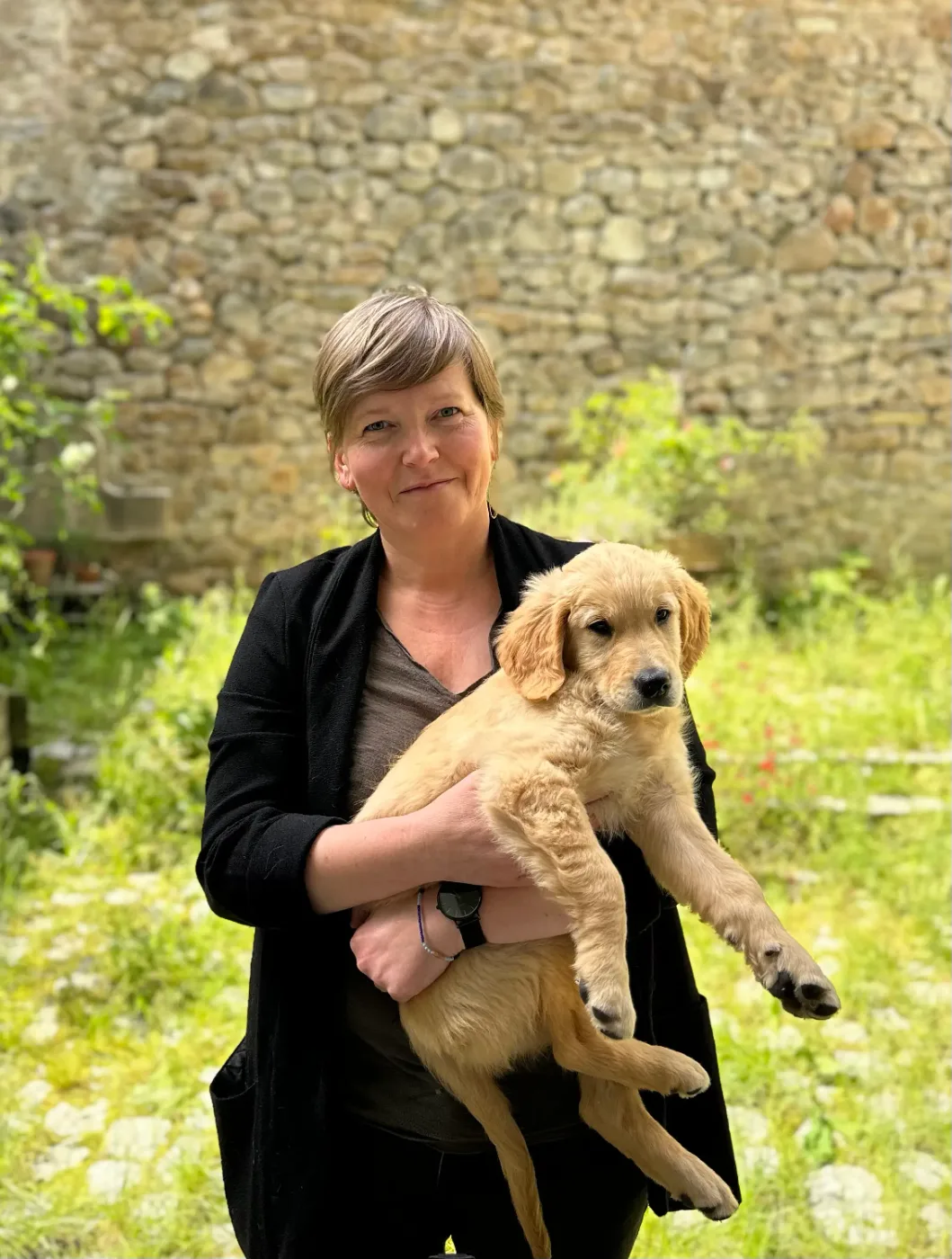 Emmanuelle Archambault en extérieur, tenant Uno, son golden retriever